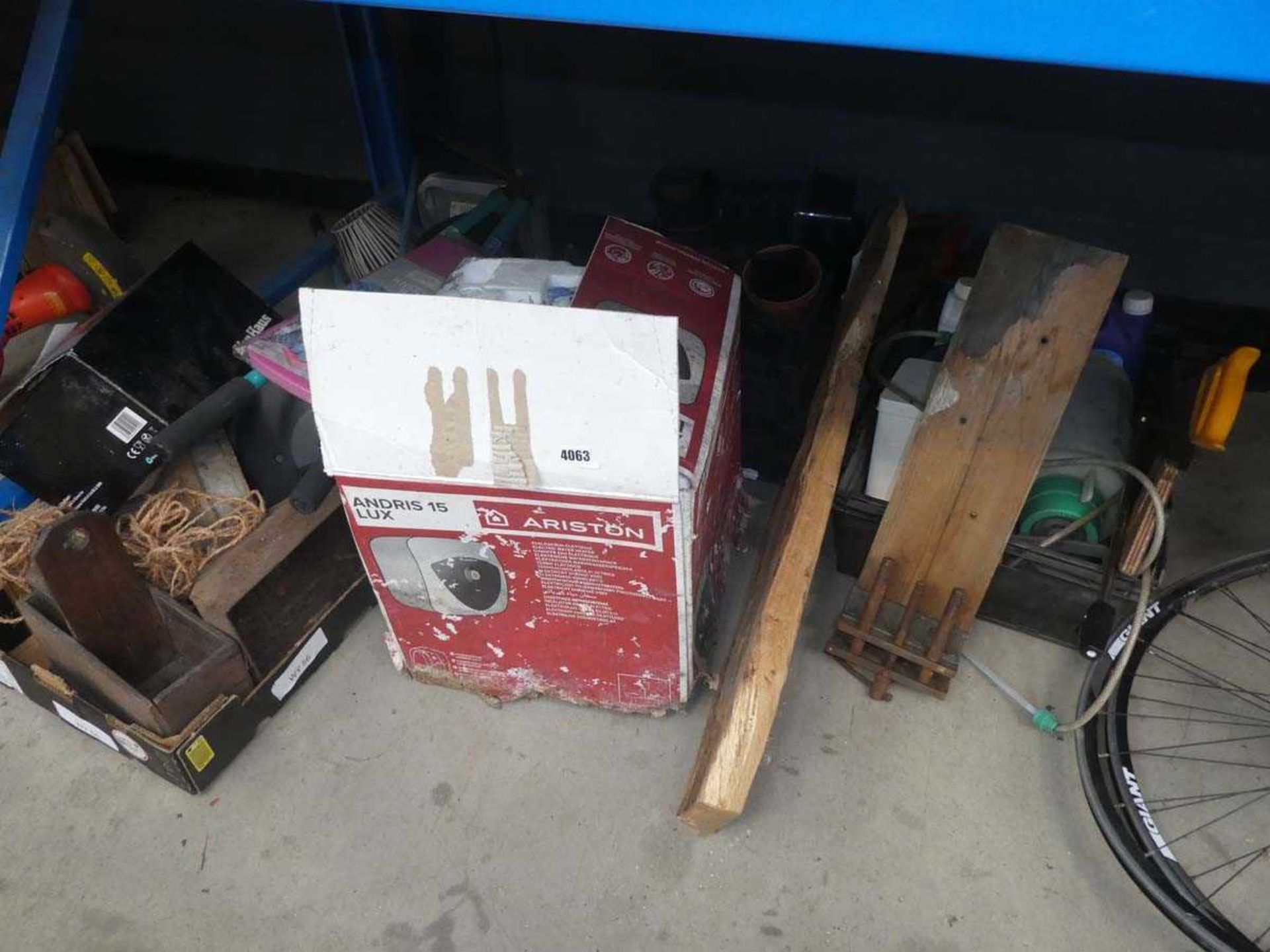 Half underbay of water heater, wooden shelf, vice, plant pots, tools,