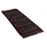 A Persian woollen runner decorated with five panels within matching bands, 183 x 67 cm