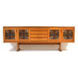 A 1960/70's Danish teak sideboard with a bank of four drawers flanked by two pairs of tile-