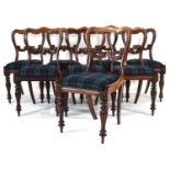 A set of eight Victorian rosewood dining chairs with scrolled balloon backs on reeded baluster