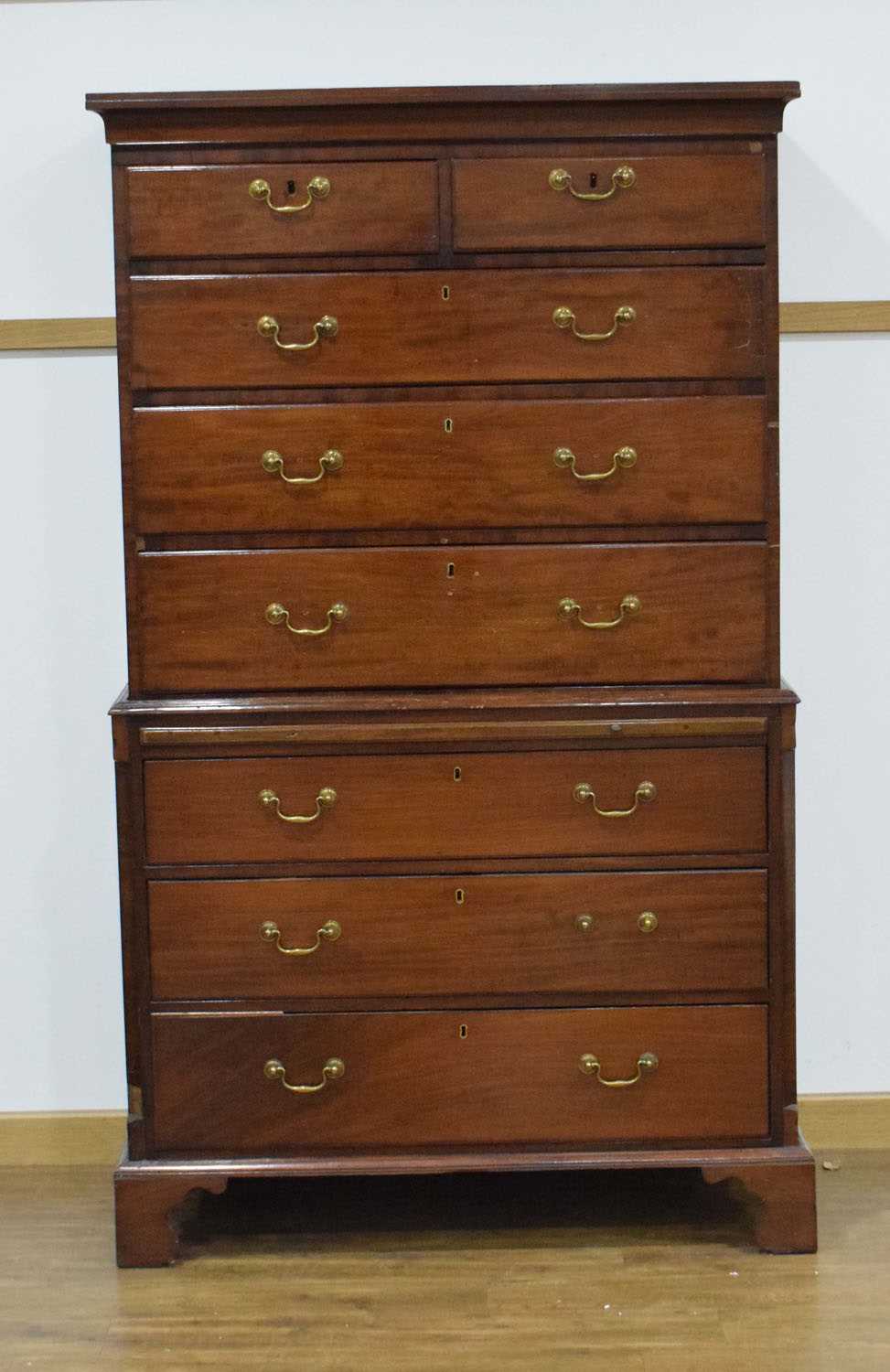 A Georgian mahogany chest-on-chest with an arrangement of eight drawers and a slide, on bracket