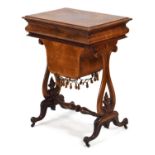 A Victorian walnut sewing table, the lid opening to reveal a fitted beech interior with sliding
