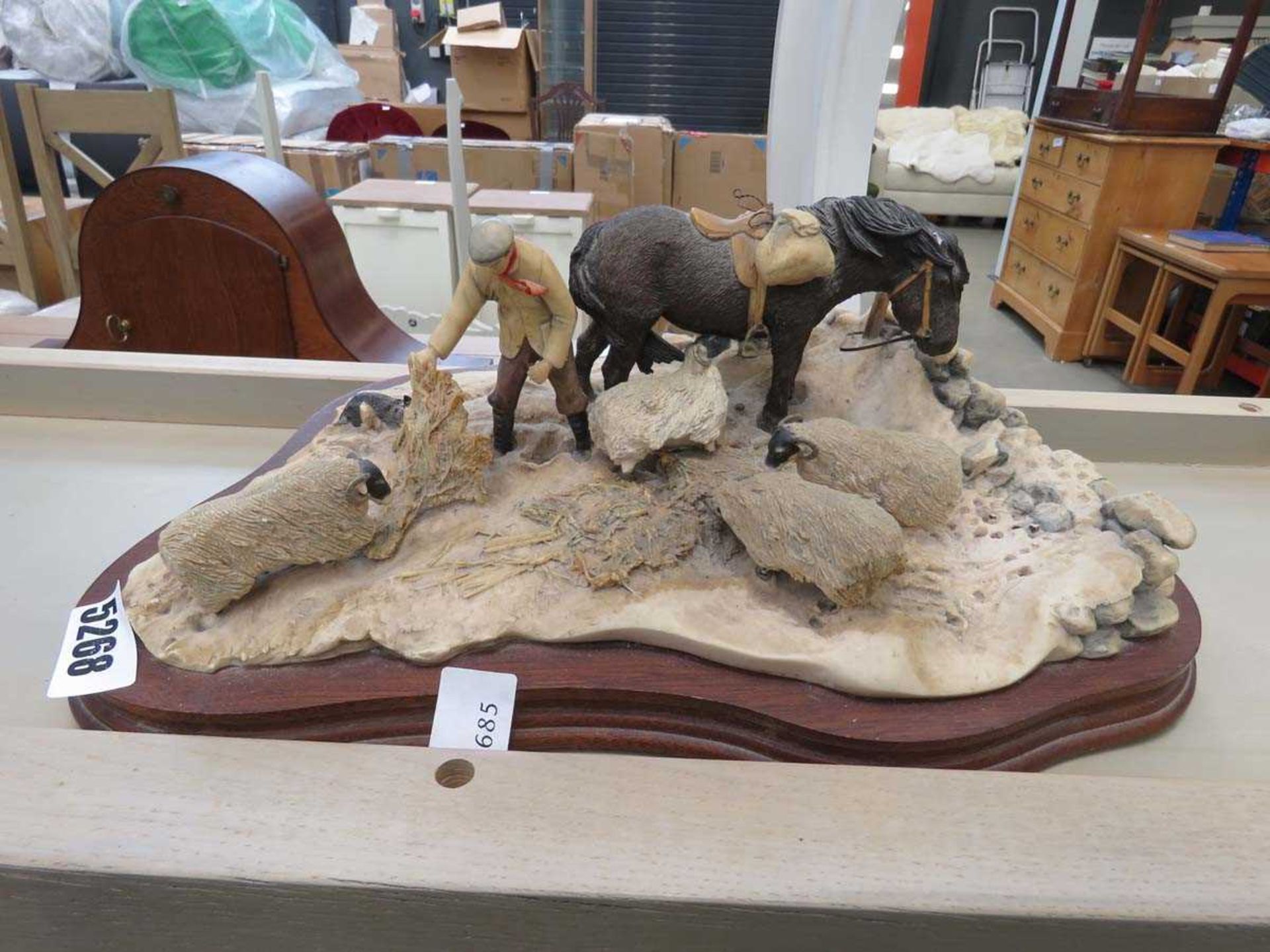 Resin figure of farmer feeding sheep