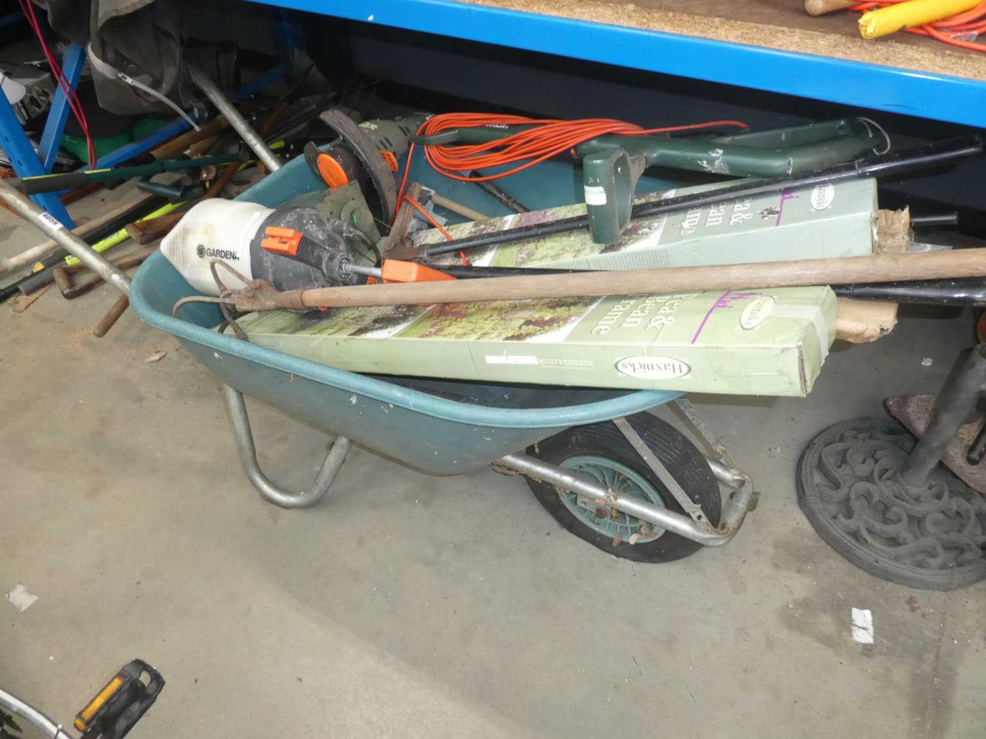 Wheel barrow containing strimmer, sprayer, hoe etc