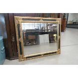 Rectangular bevelled mirror in black and gilt painted frame