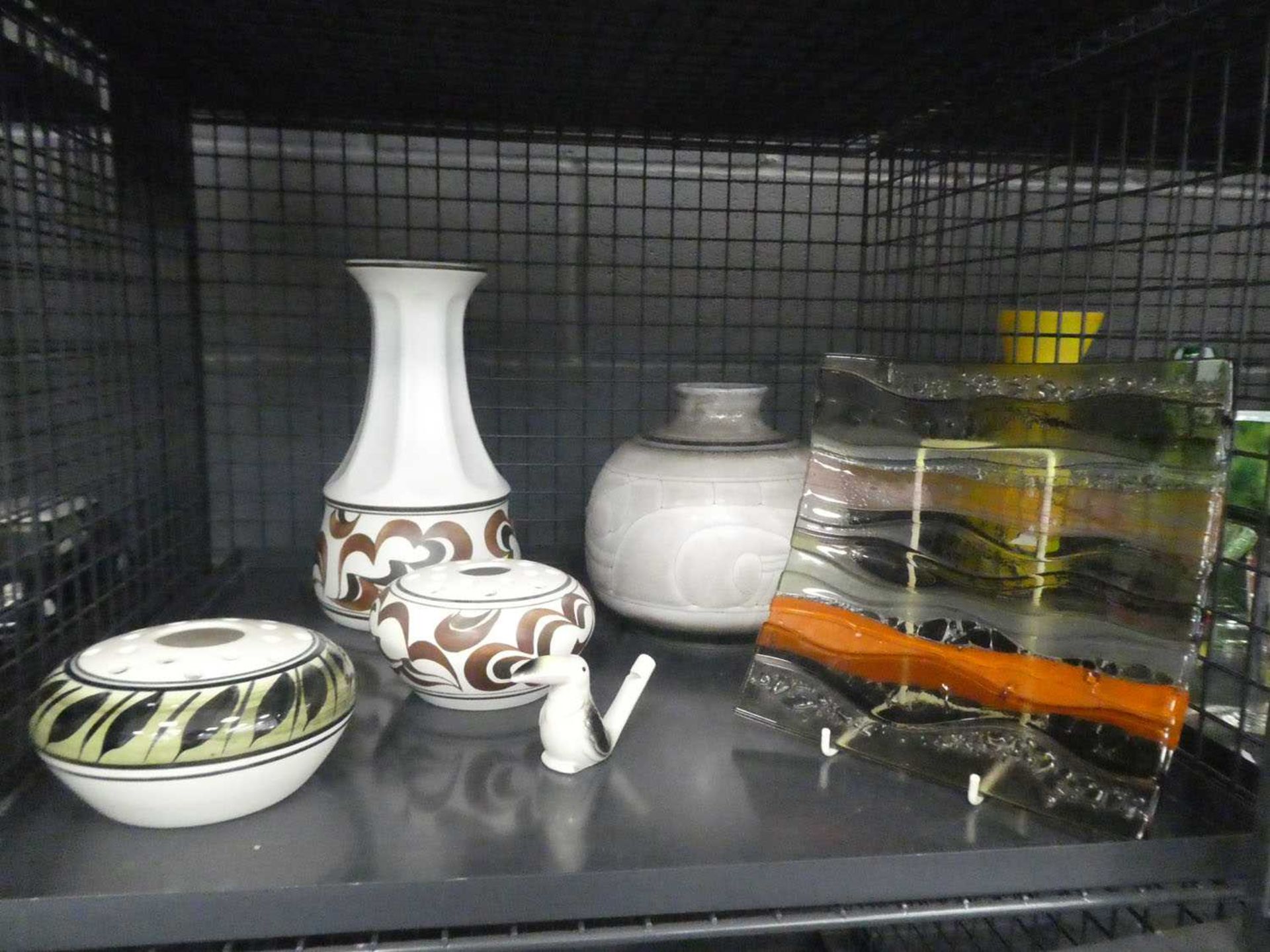 Cage containing studio pottery, glass bowl, and toucan whistle