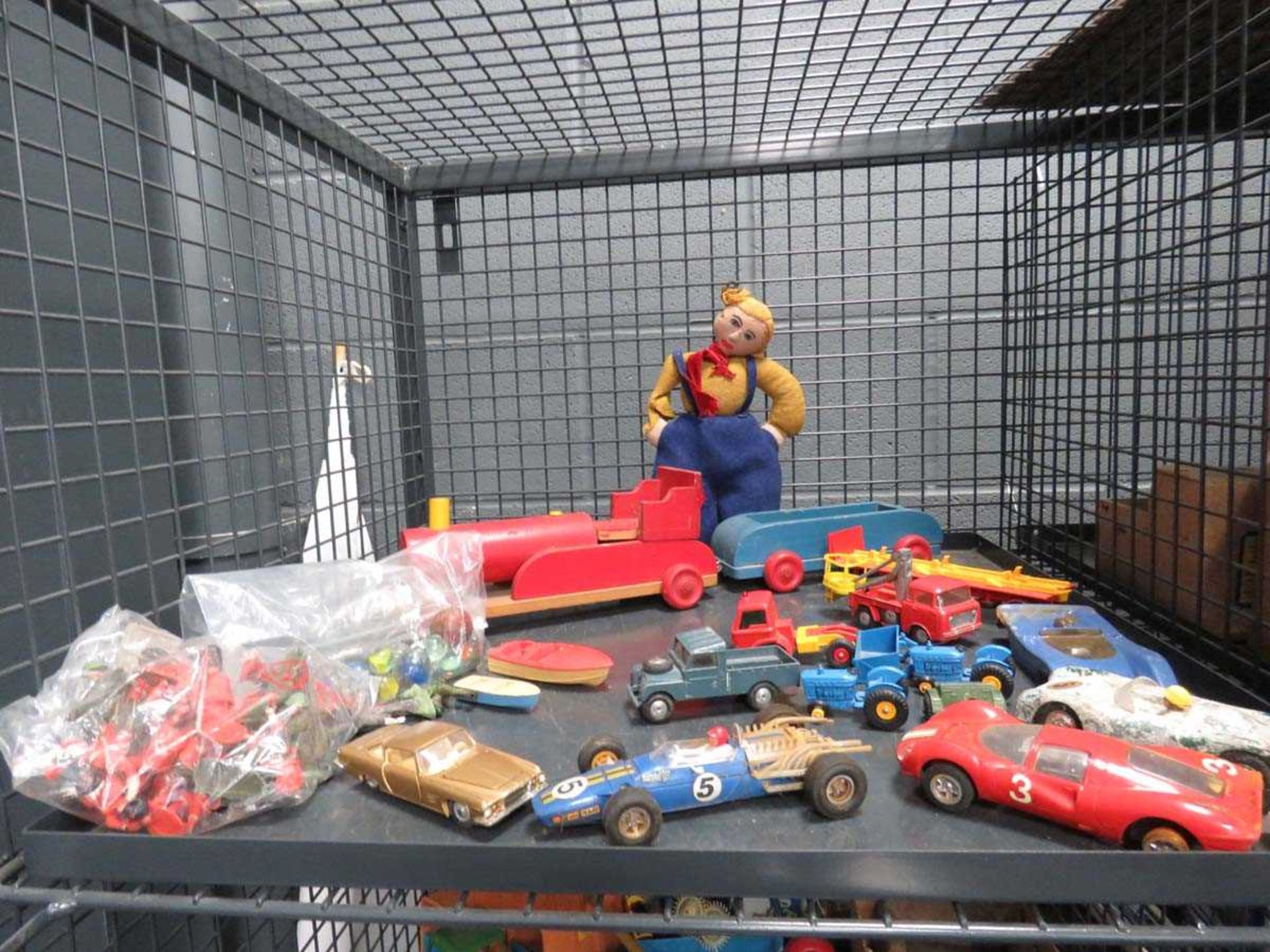 Cage containing die cast toys, plastic soldiers, marbles, and wooden cart