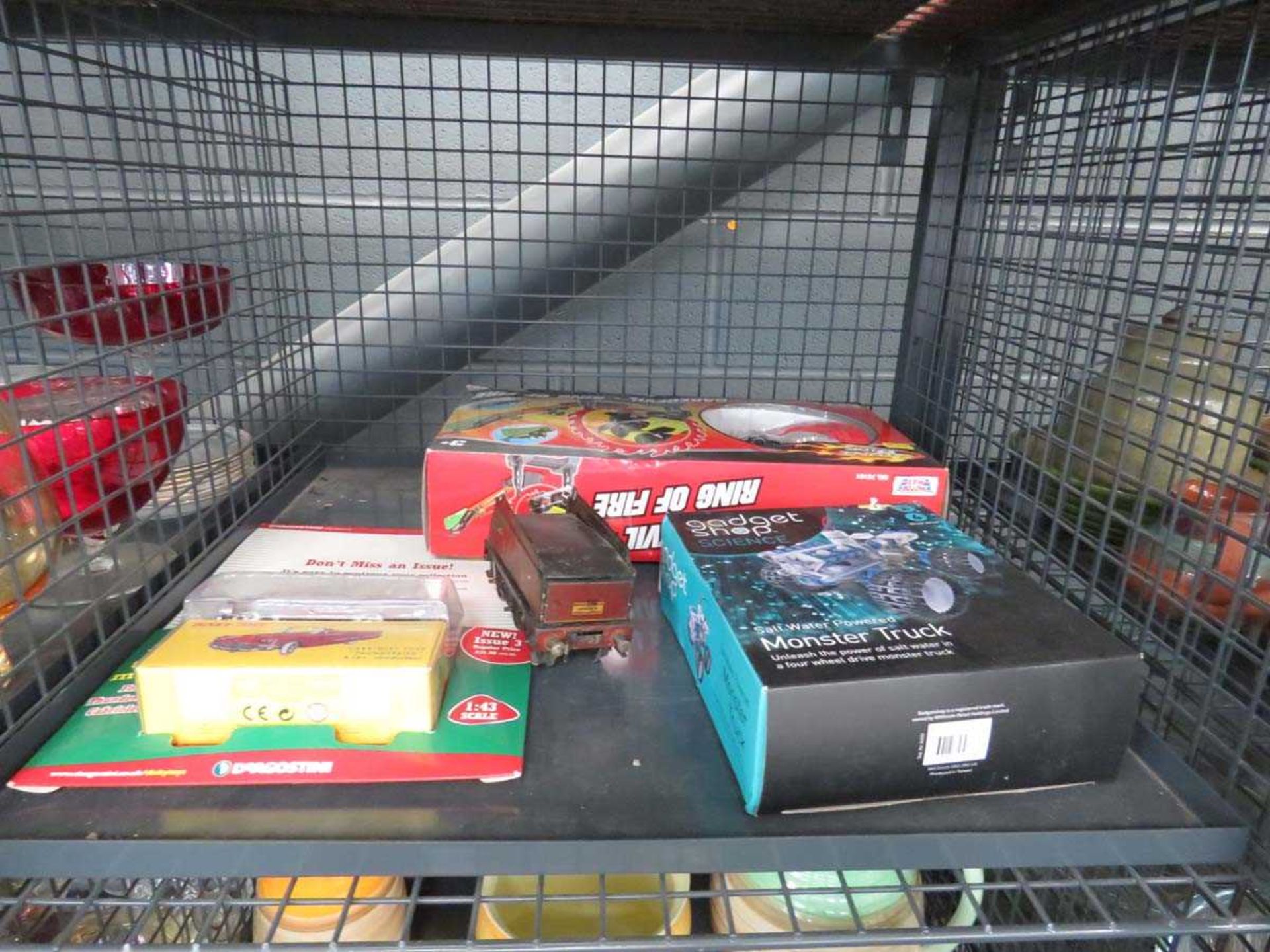 Cage containing a quantity of boxed toys and a tin plate rolling stock