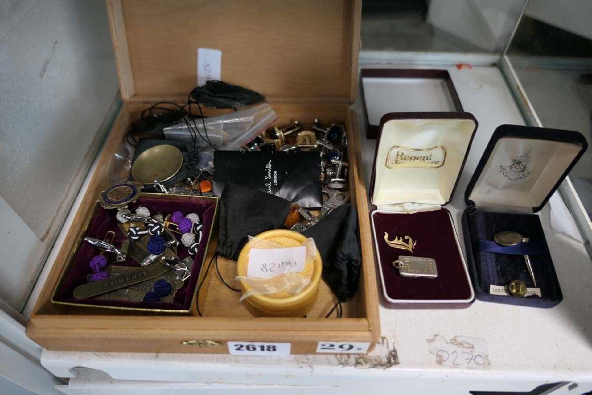 Box containing various collectable cufflinks and other items including a small ingot marked 999