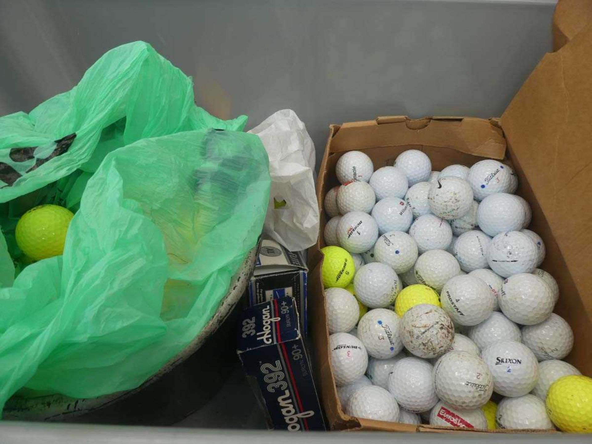 Two boxes of assorted golf balls and golfing items