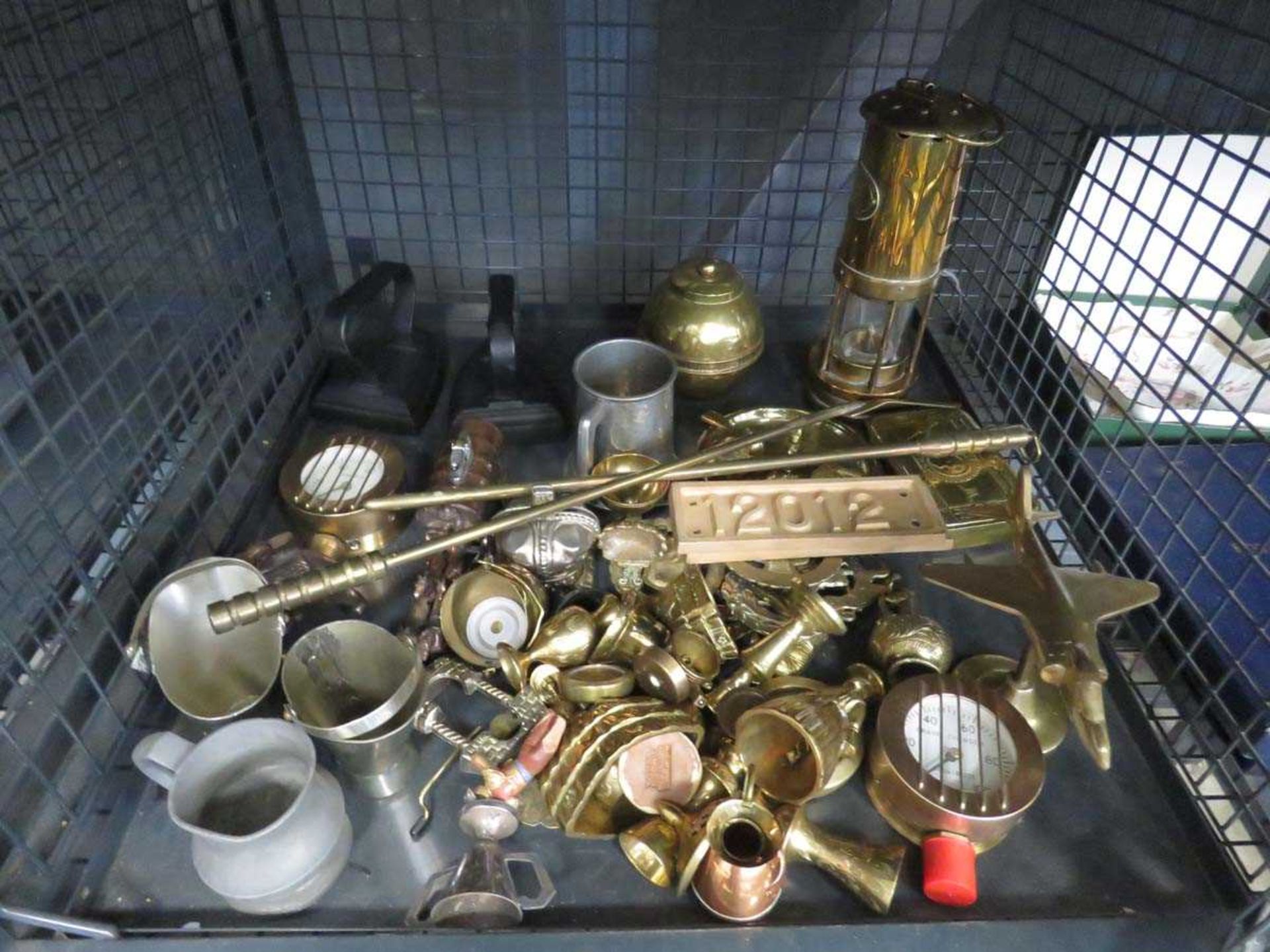 Cage containing flat irons, miners lamp, brass figures and pewter ware