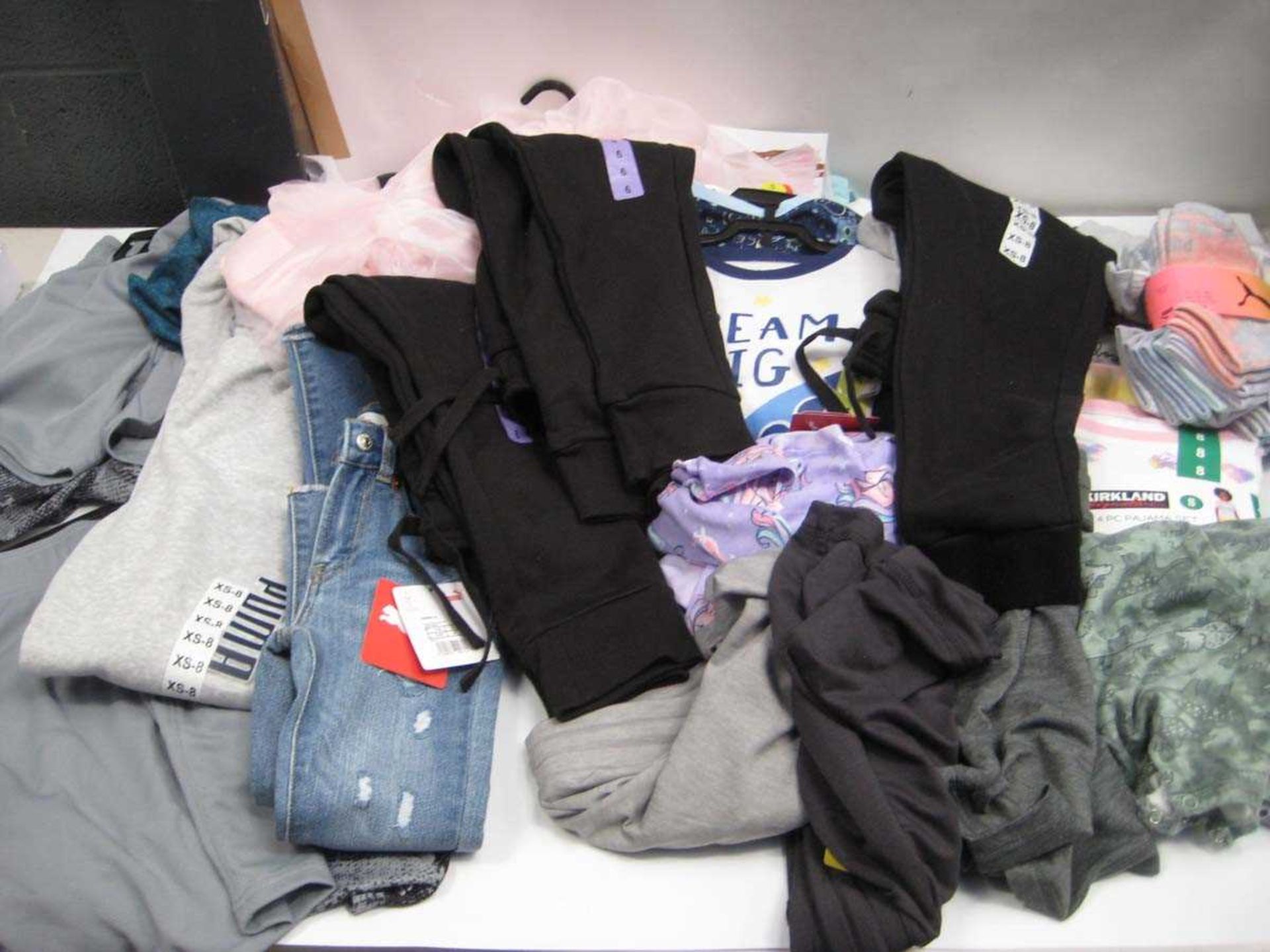 A bag containing Children's Clothing in various sizes, including Levi Jeans, Puma Jogger, Champion