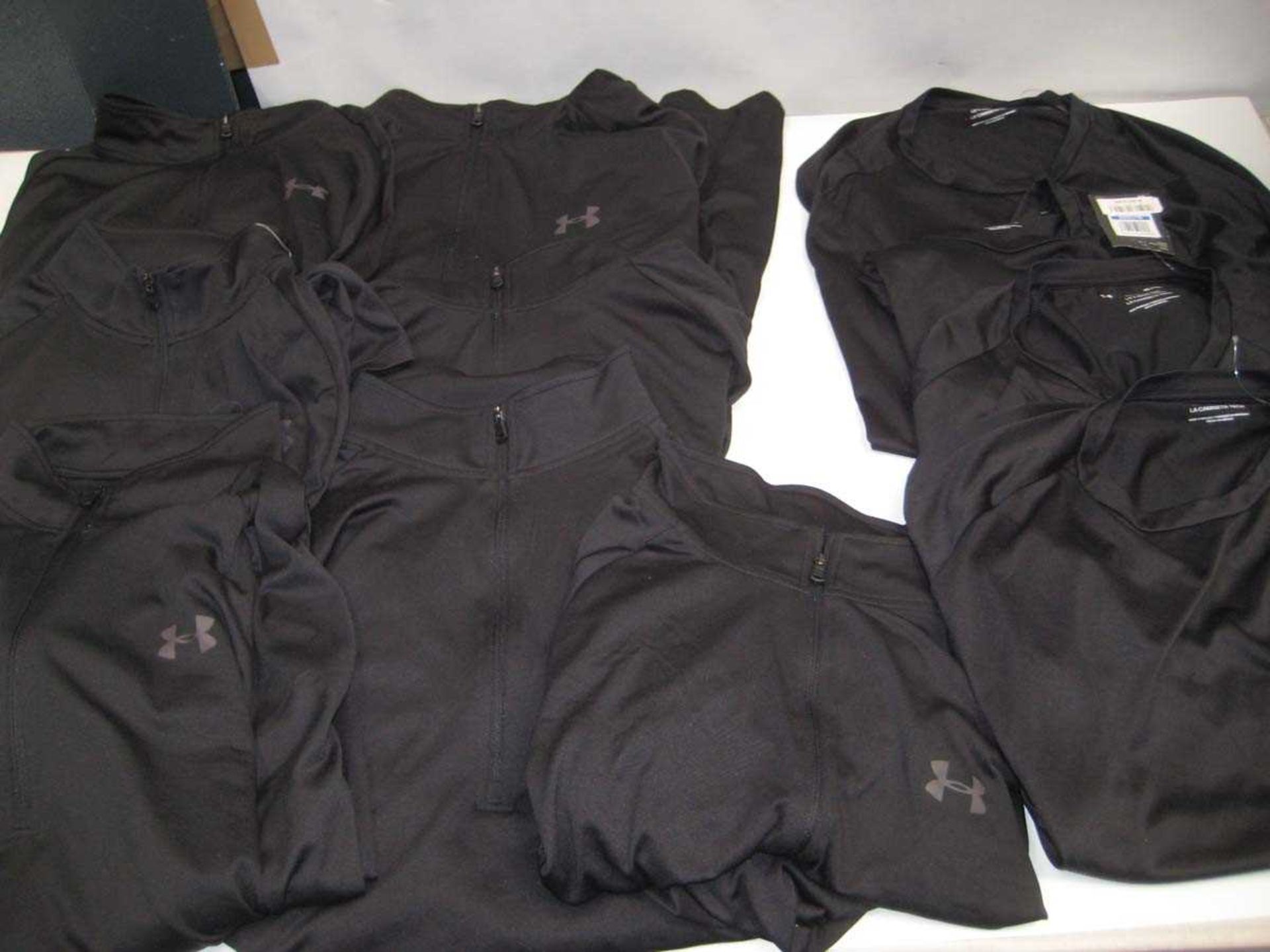 +VAT A bag containing 7x Under Armour Black Training Tops & 4x Under Armour Black T Shirts in