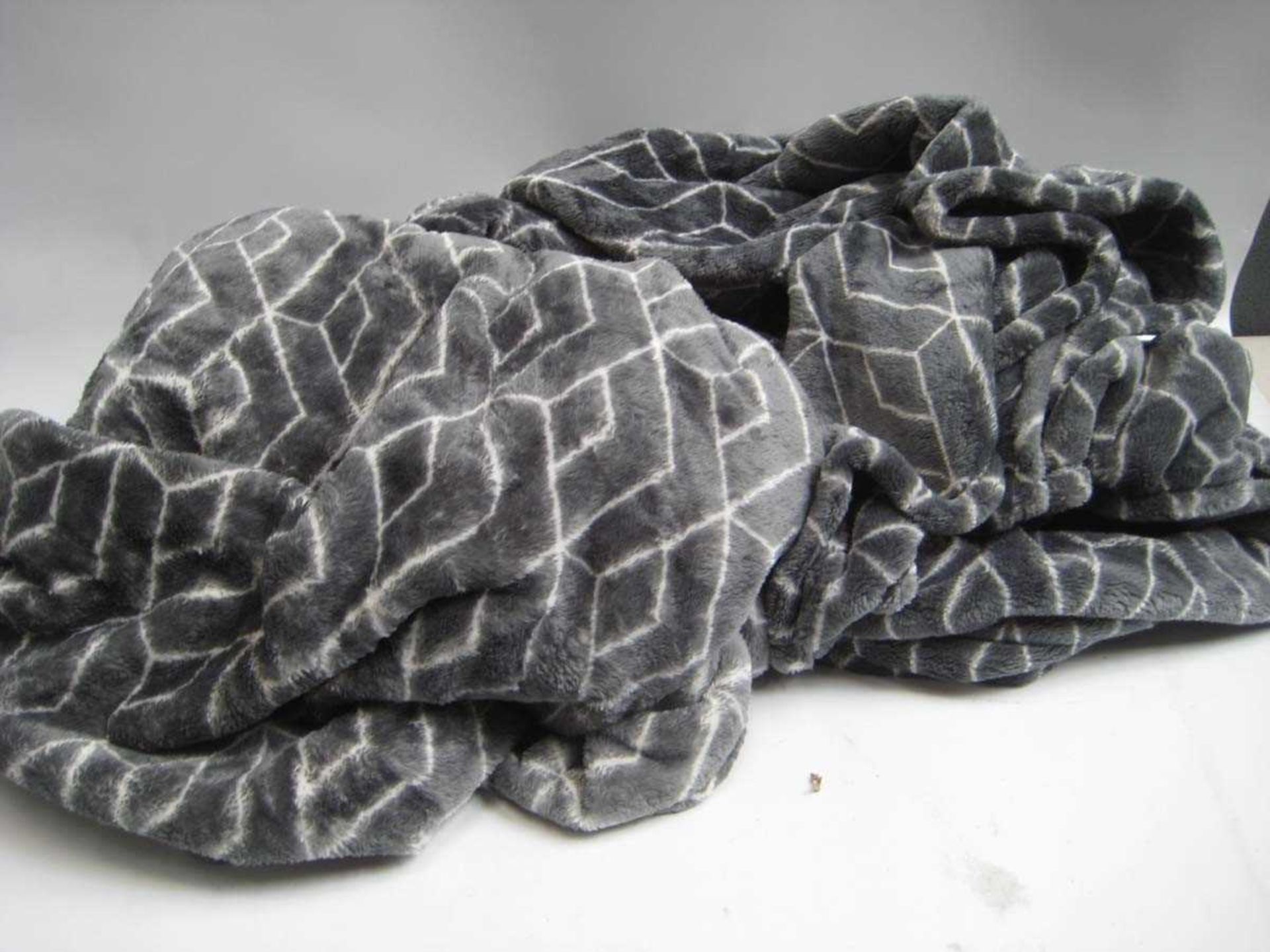 +VAT A bag containing 2x Large Grey Patterned Throws.