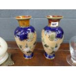 A pair of Royal Doulton ovoid vases, typically decorated with blossoming branches on a blue/buff