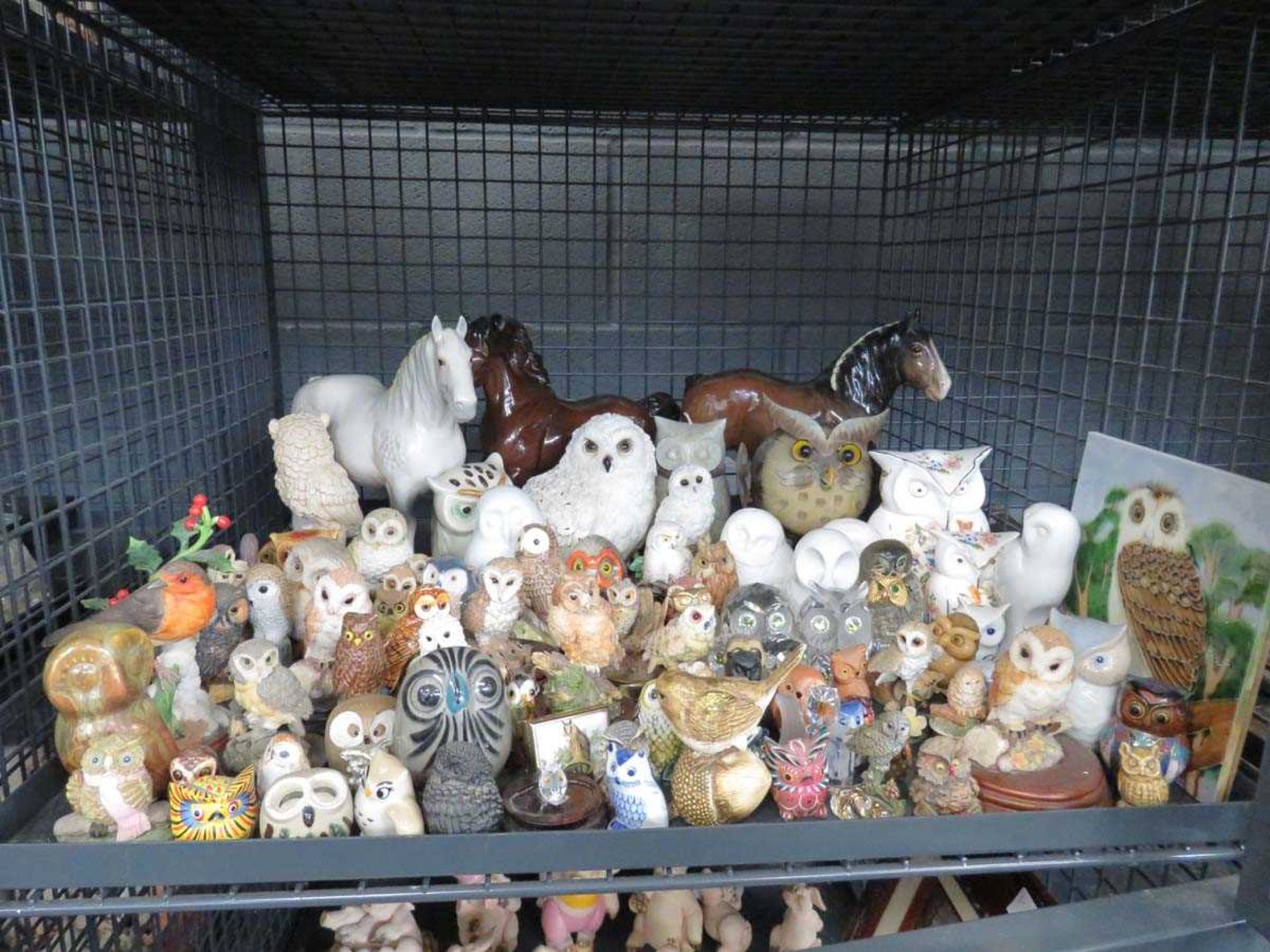 Cage containing large quantity of ornamental owls and horses