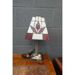 Small metal table lantern with red and white glass shade