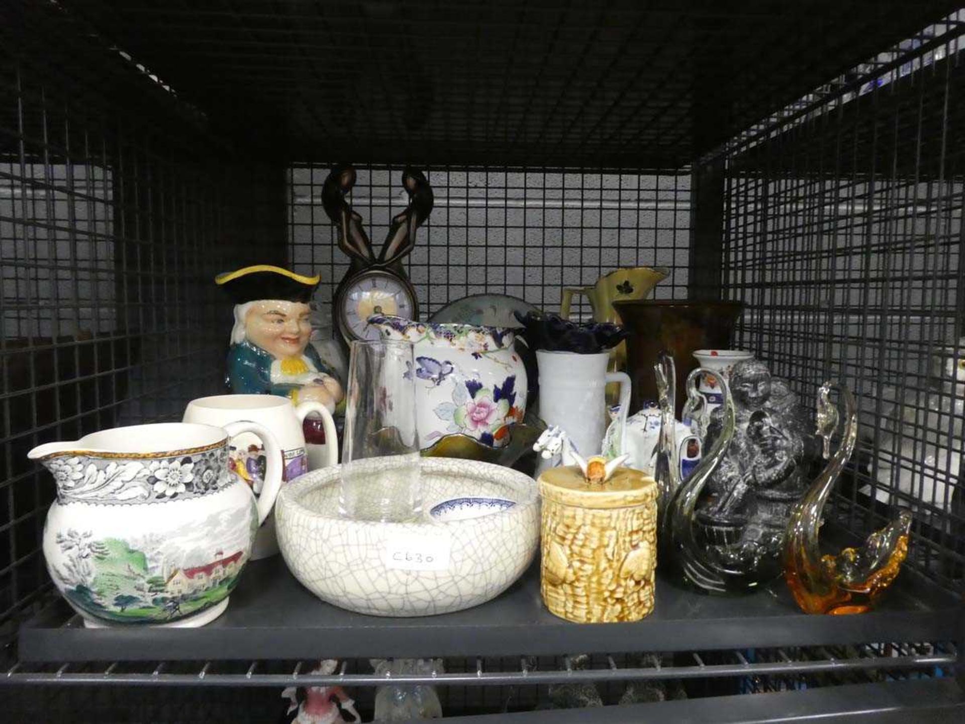 Cage containing a quartz clock, toby jug, honey pot, swan shaped glass dishes and various vases