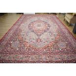 A modern carpet, the central medallion surrounded by a red ground richly decorated with floral