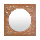 In the manner of Newlyn School, an Arts & Crafts hammered copper wall mirror with vine decoration