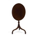 A Georgian mahogany tilt-top table, the oval surface on a turned column and three splayed legs