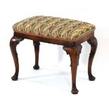 A reproduction walnut stool, the upholstered surface on four cabriole legs with pad feet