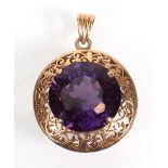 A 14ct yellow gold pendant of circular form set round cut amethyst within a scrolled setting, d. 2.7