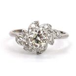 An 18ct white gold ring set brilliant cut diamond in a raised six claw setting, the shoulders set