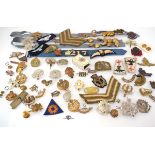 A collection of military cap badges, buttons, shoulder patches, match cover etc.