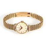 A ladies 9ct yellow gold wristwatch by Omega, the circular dial with gold coloured baton numerals on