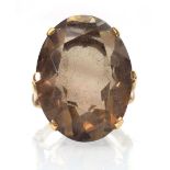 A 9ct yellow gold dress ring set oval smoky quartz in a raised setting,ring size J,10.4 gms