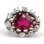 An 18ct white gold ring set oval synthetic ruby in an eight claw setting within a border of ten