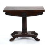 An early 19th century rosewood folding card table on turned column, platform base and claw feet,