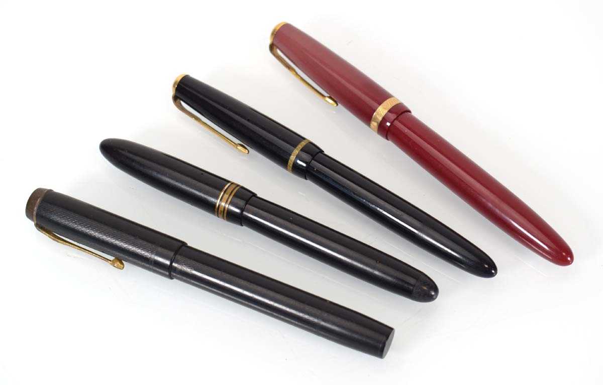 A group of four fountain pens, each with a 14ct gold nib