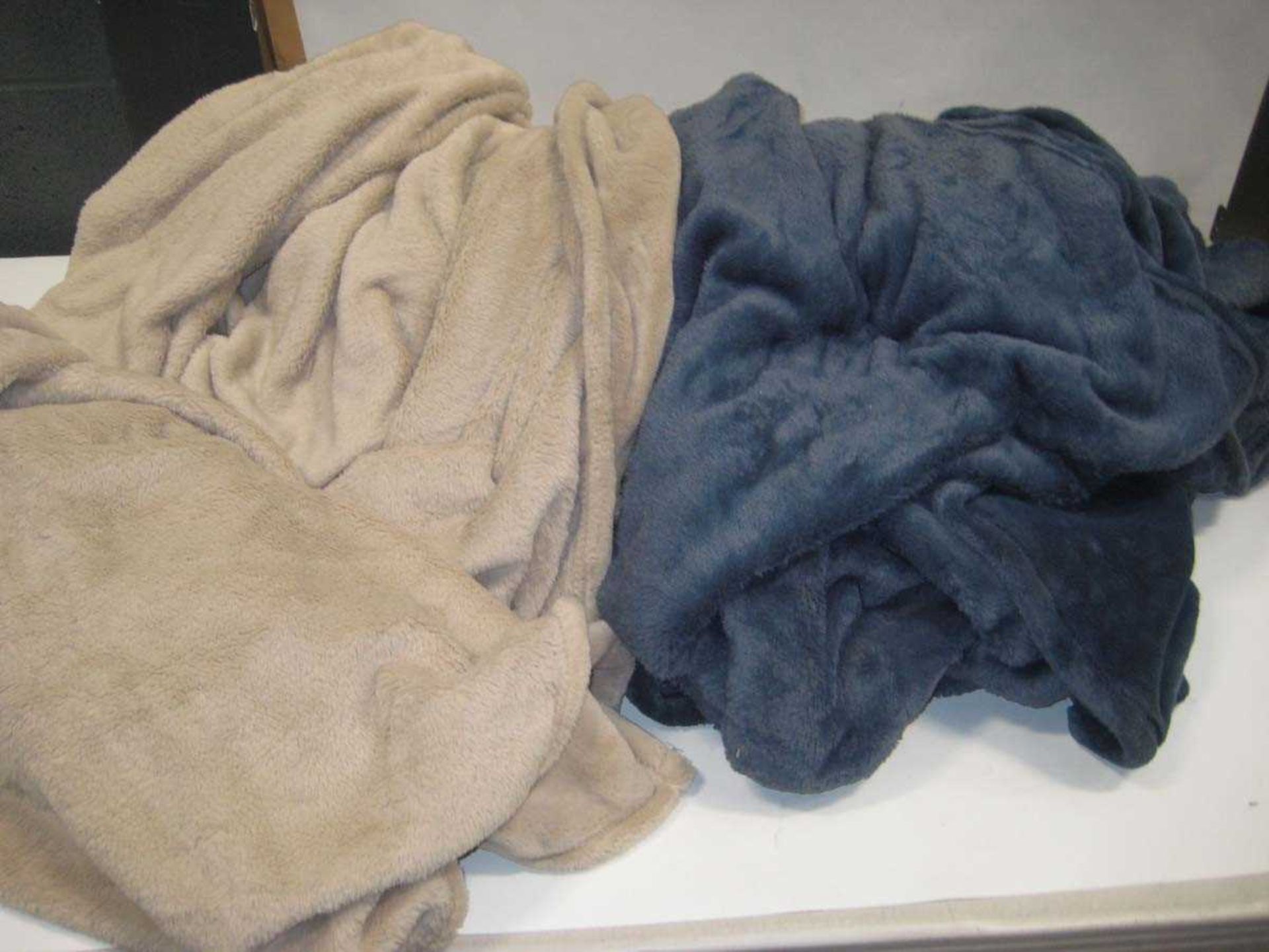 +VAT A bag containing 2x Large Throws in Beige & Navy.