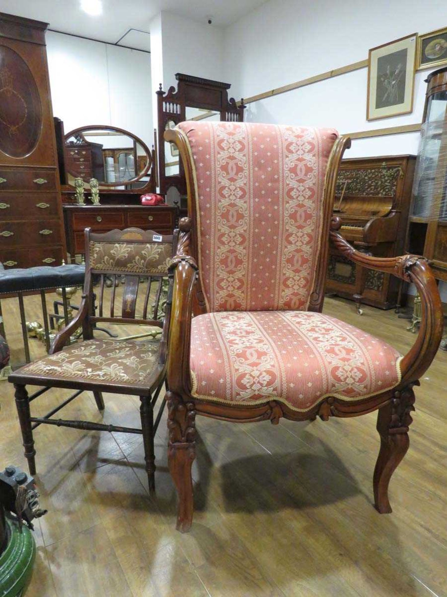 Red upholstered armchair on carved wooden frame together with a slender inlaid bedroom chair