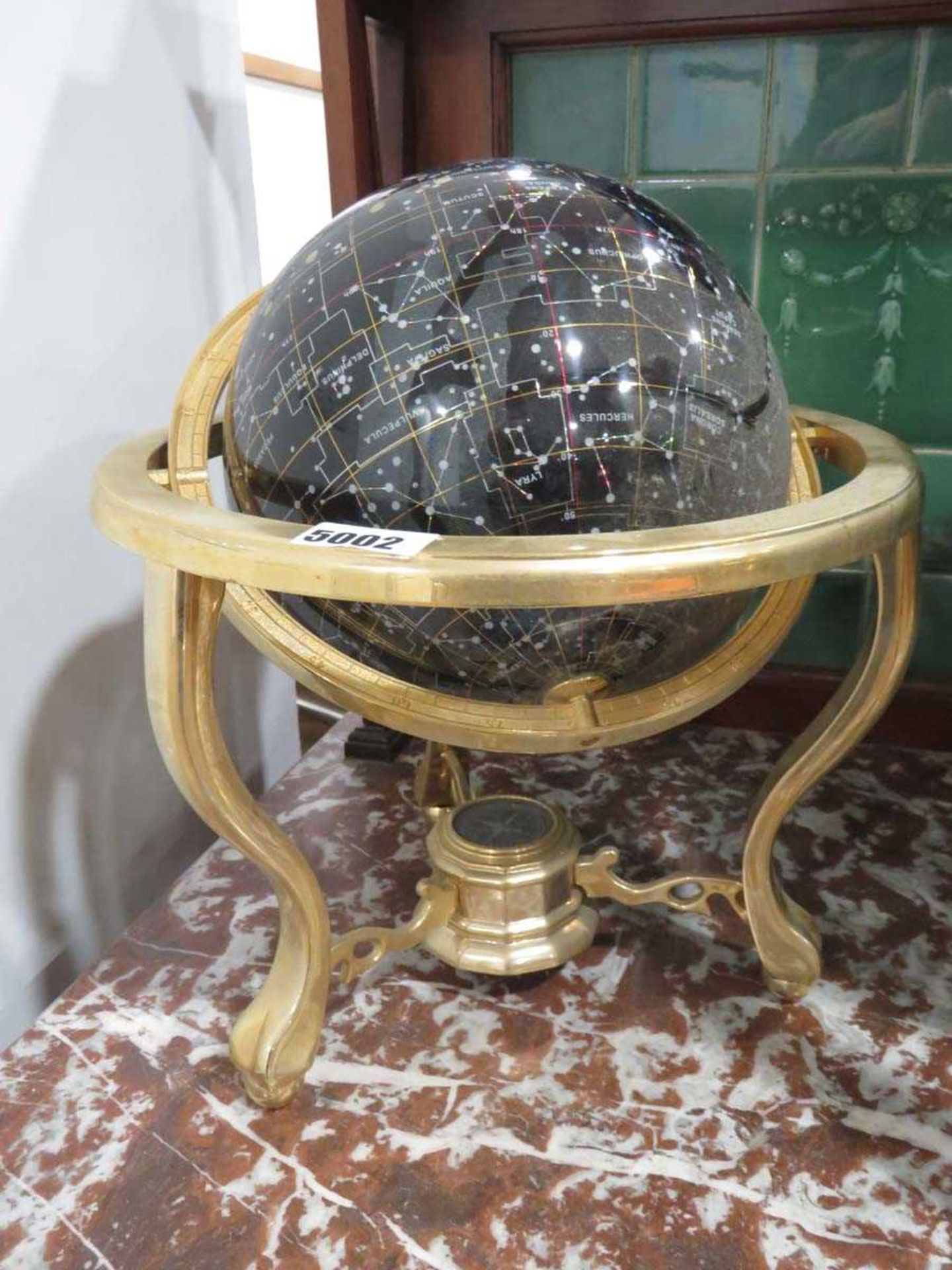 Small gem set astronomical globe contained within a brass stand