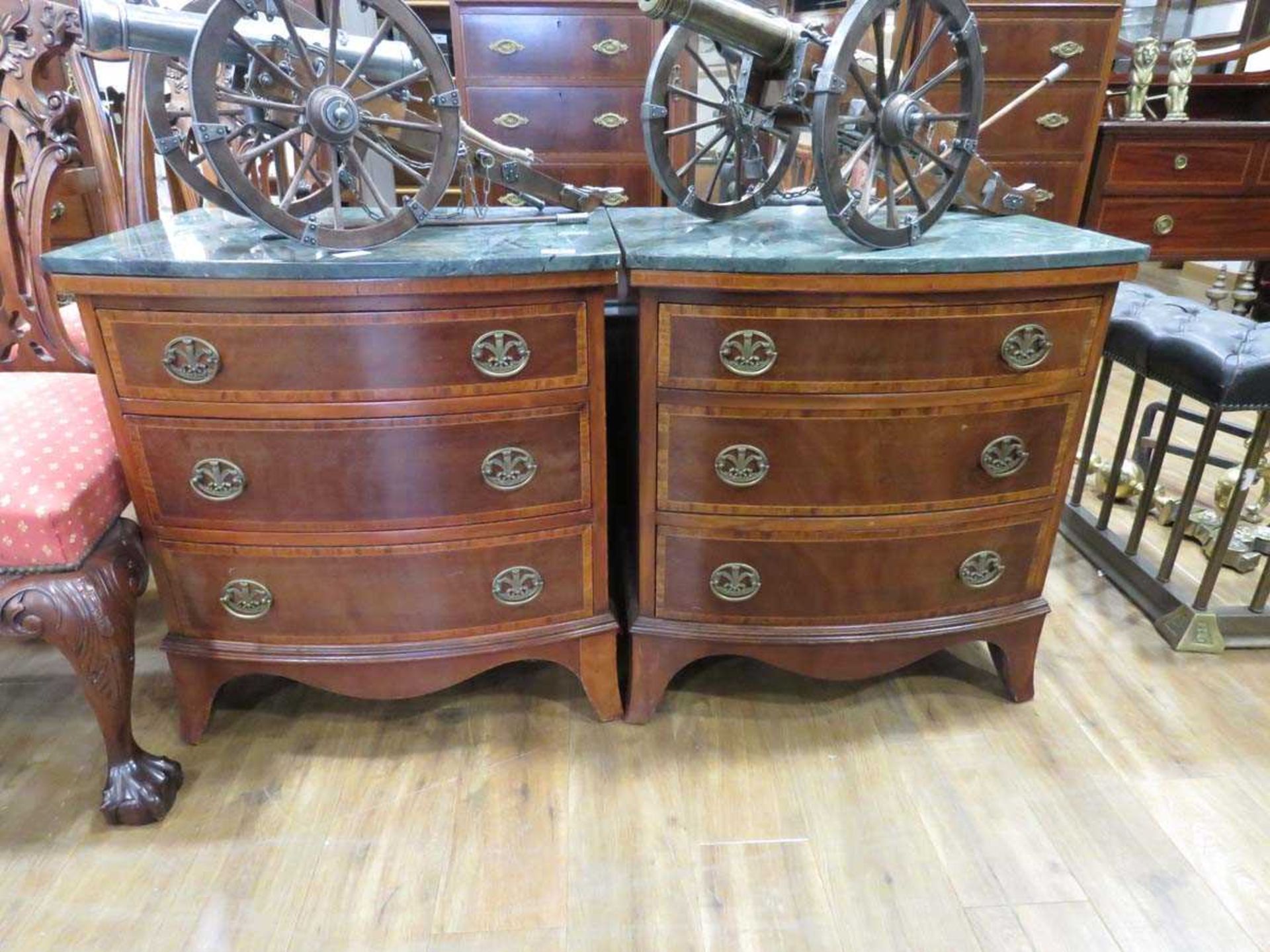 Pair of mahogany bow fronted marble topped three drawer chests