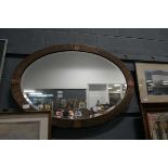 Arts and Crafts oval bevelled mirror in a beaten copper frame