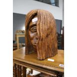 Wooden carving of female head with shoulder length hair