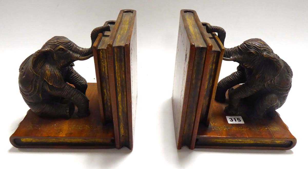 A pair of Elephant Book ends. Cast metal bronze-type seated elephants mounted on carved wooden