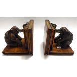 A pair of Elephant Book ends. Cast metal bronze-type seated elephants mounted on carved wooden