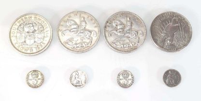 A small group of coins including a 1922 Liberty dollar, two 1935 crowns, a Southern Rhodesian 1953