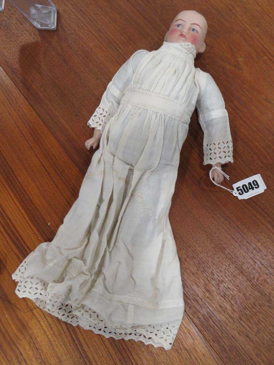 An early 20th century bisque shoulder head doll with painted features, l. 39 cm (af)Large chip to