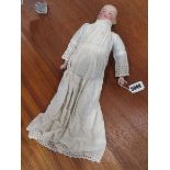 An early 20th century bisque shoulder head doll with painted features, l. 39 cm (af)Large chip to