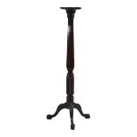 A late Victorian mahogany torchier plant stand with a carved body, tripod legs and claw feet