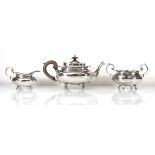 An early 20th century silver three piece tea service of oval form on scroll feet, James Dixon,