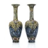 A pair of Royal Doulton bottle vases, each relief decorated with stylised flowers on a mottled