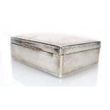 An Edwardian hammered silver cigarette box of cushioned rectangular form, Deakin & Francis,