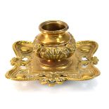 A late 19th/early 20th century brass inkwell with a gadrooned body and scrolled sides, w. 17 cm